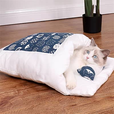 chat blanc dans son panier chat en forme de sac de couchage